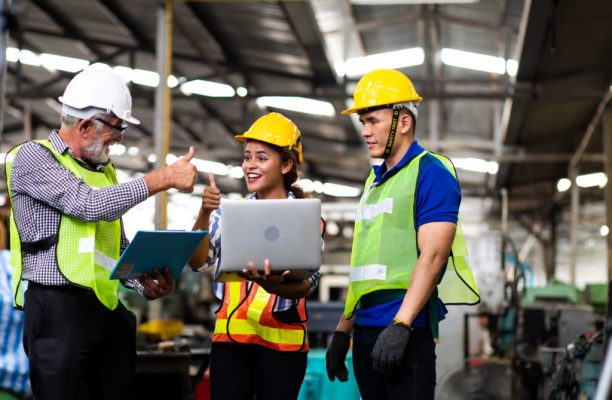 Professional Mechanical Engineer team Working on Personal Computer at Metal lathe industrial manufacturing factory. Engineer Operating  lathe Machinery. Product quality Inspection